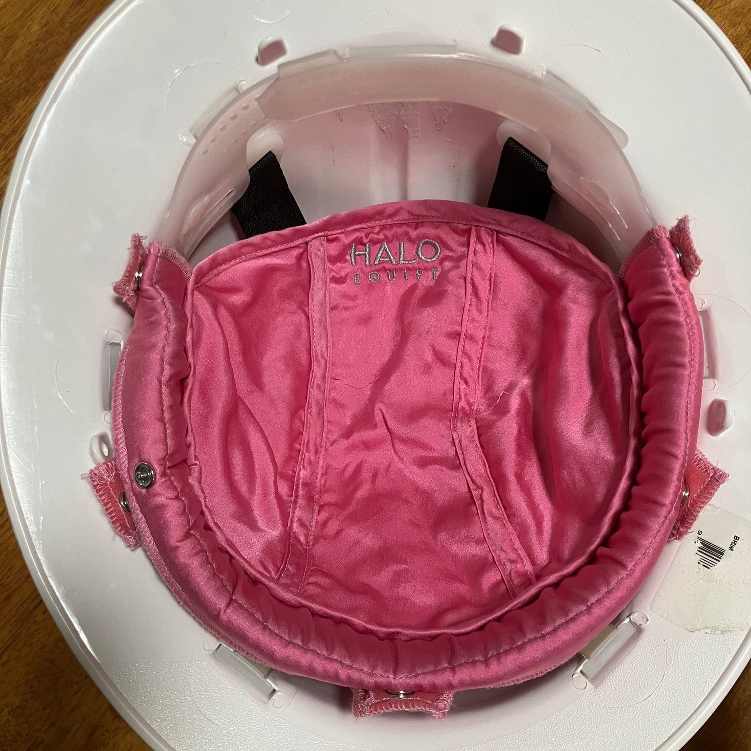 The pink HALO Lid Liner held in one hand, showing the silk surface