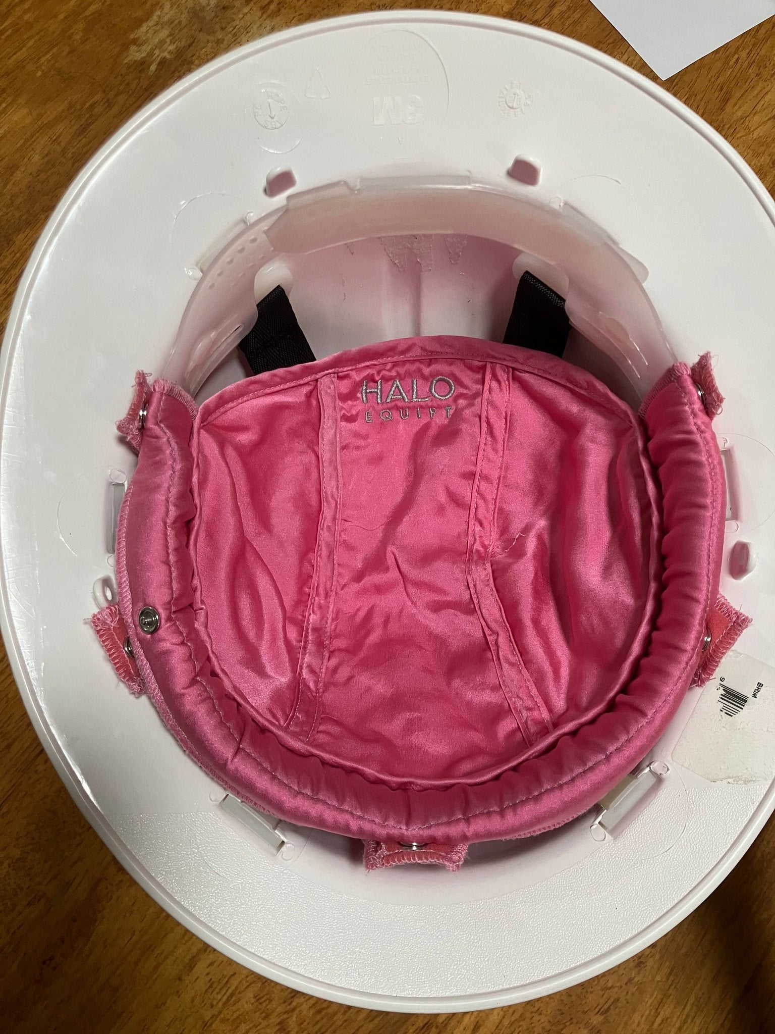 The pink HALO Lid Liner held in one hand, showing the silk surface